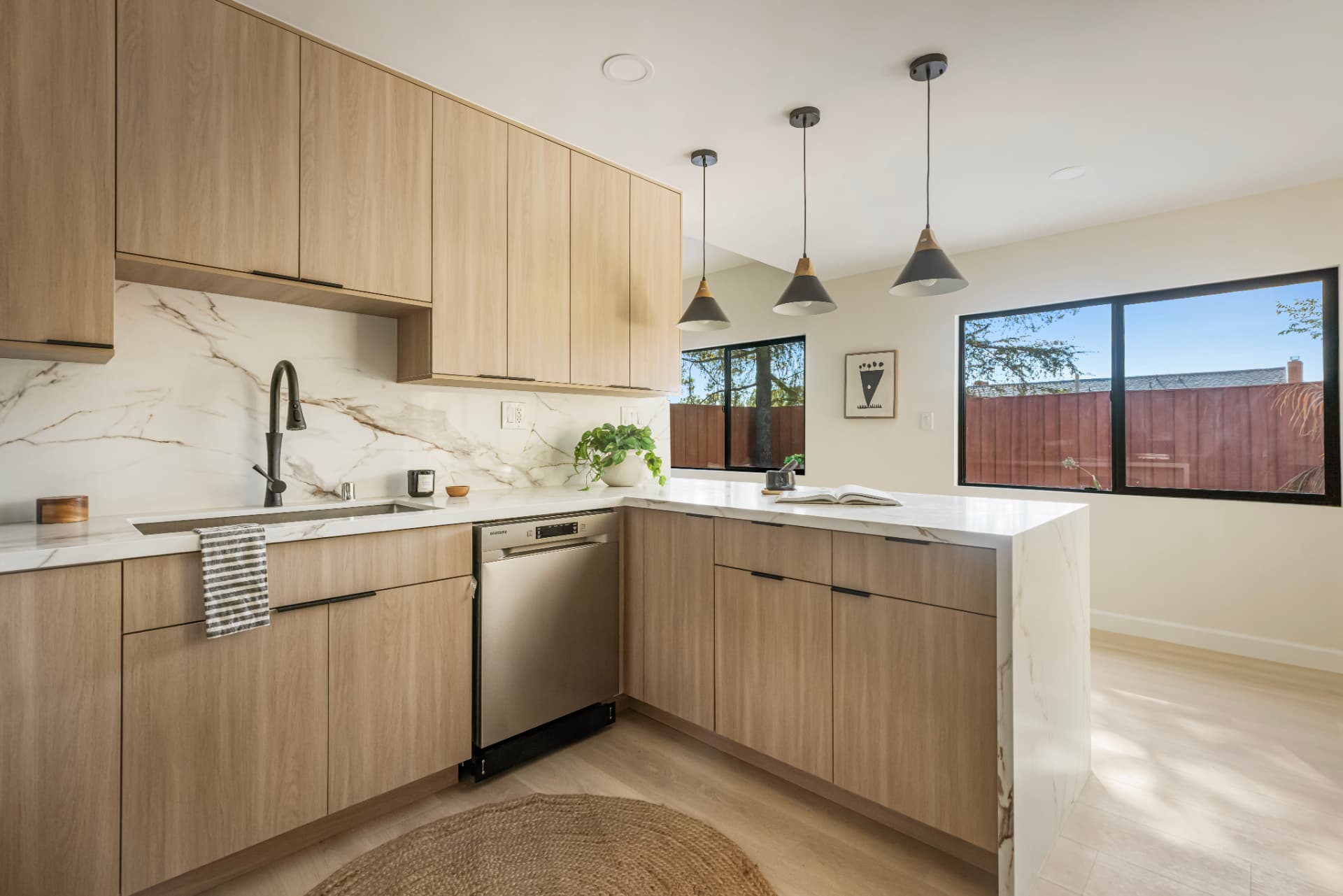 Kitchen sink run beneath black-framed windows