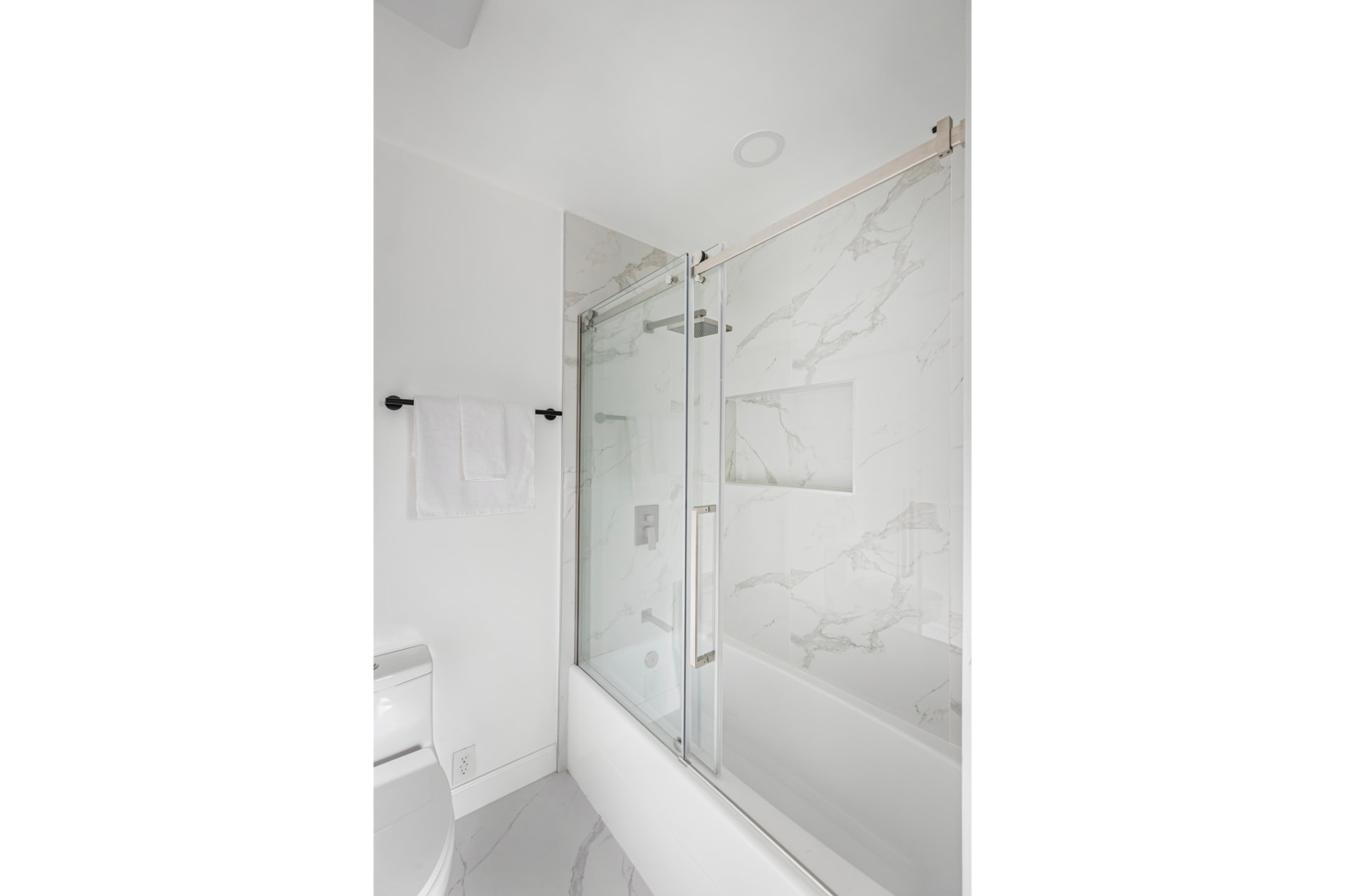 Bath with marble-look surround and glass enclosure