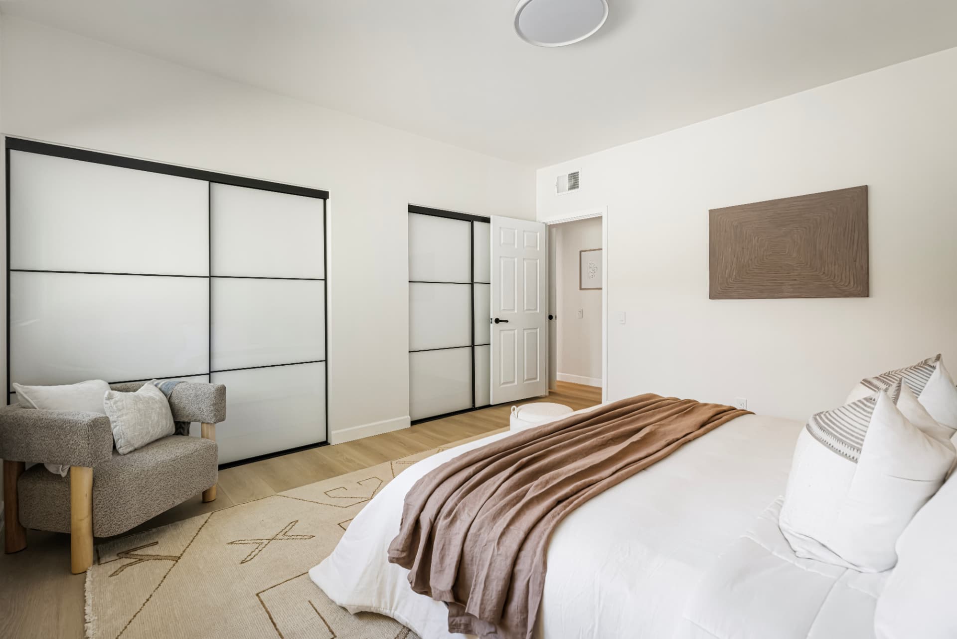 Bedroom with dual sliding closets and reading chair