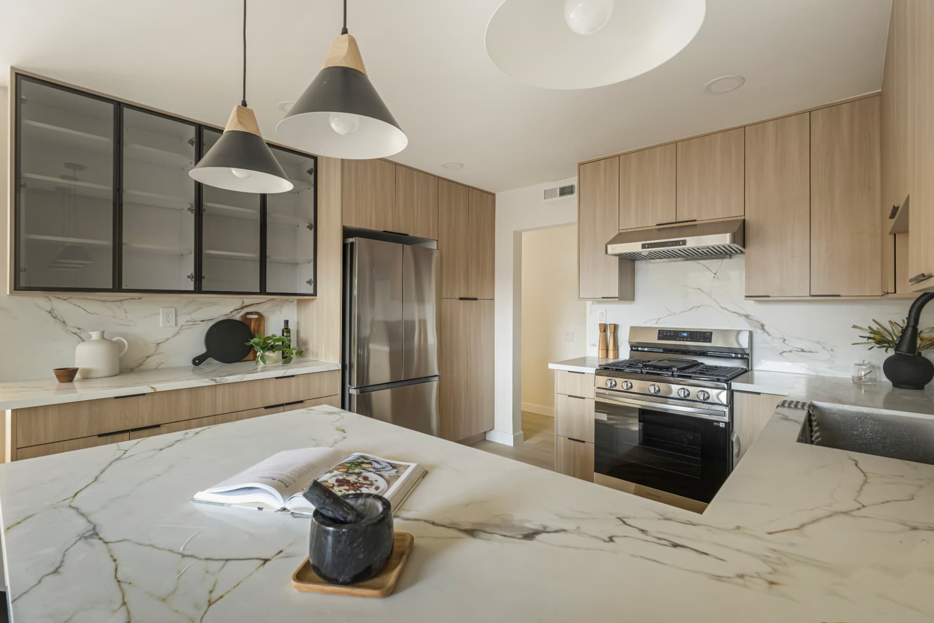 Stone island countertop with glass-front upper cabinetry
