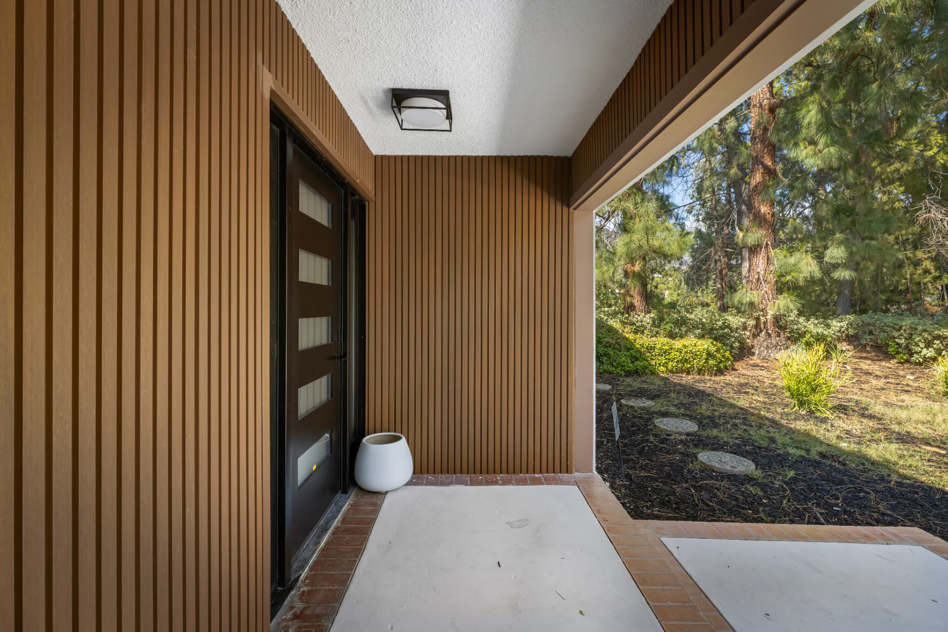 Covered entry breezeway lined in warm vertical wood
