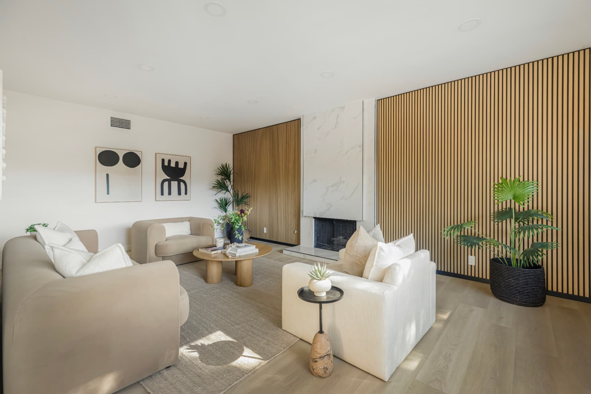 Living room with vertical wood walls and marble fireplace