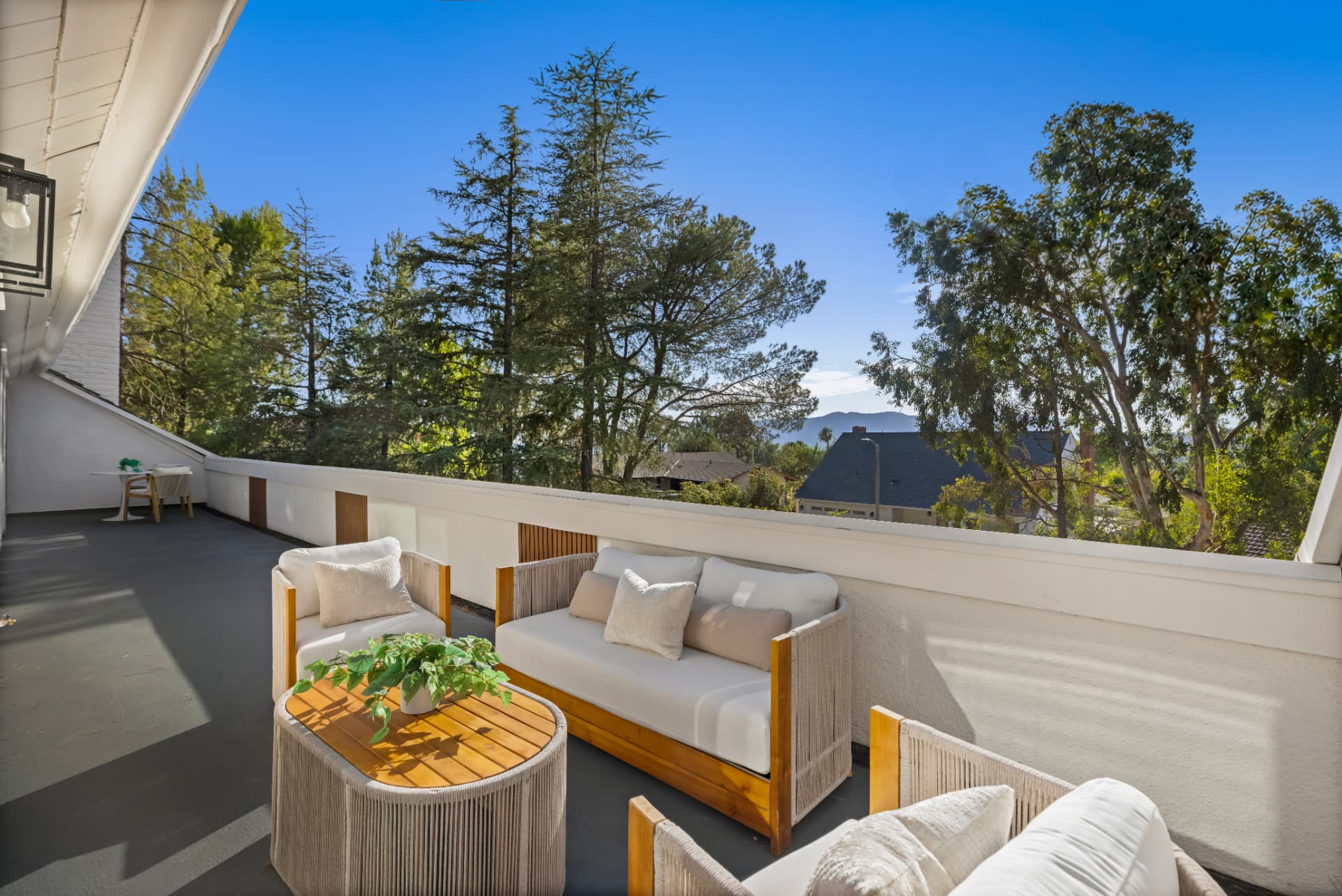 Elevated deck with lounge seating overlooking pines and the San Gabriel foothills