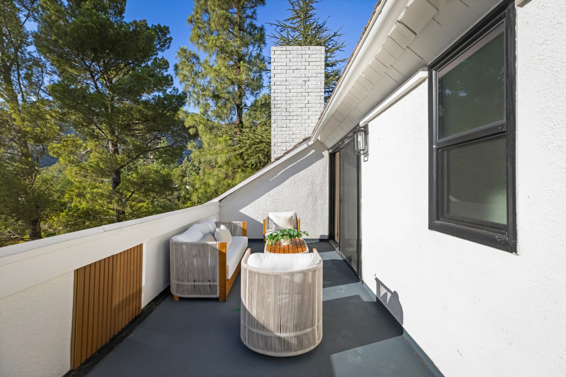 Deck running along the roofline past the white brick chimney