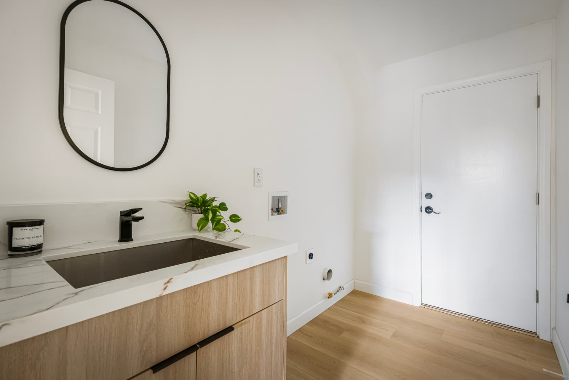 Laundry room with stone counter and wood cabinetry