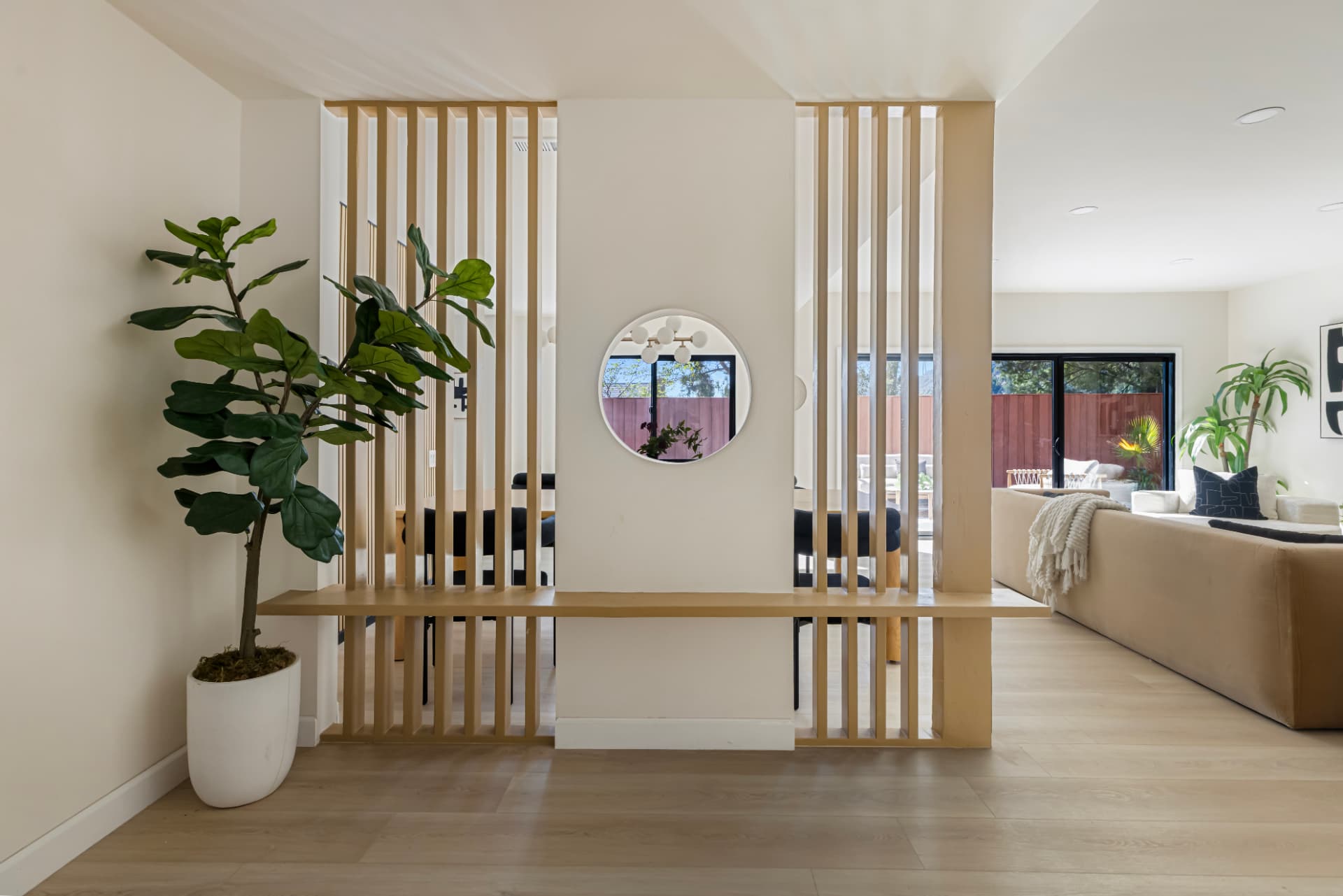 Wood slat room divider with floating bench and round window