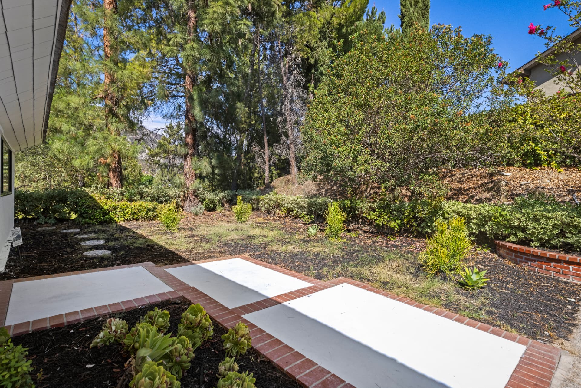 Side yard with brick-edged walkways and mature landscaping